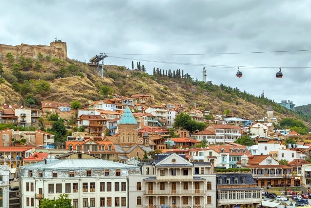 Colorful Tbilisi hillside cityscape with cable cars and historic rooftops, ideal for a Georgia holiday package from Dubai.