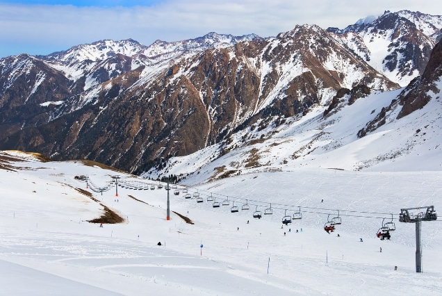 Ski lift over snow-covered Trans-Ili Alatau mountains at Shymbulak Ski Resort, Almaty, for Kazakhstan winter tours from UAE.
