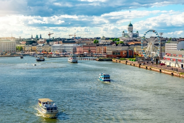 Helsinki South Harbor featuring ferries, the SkyWheel, and the iconic white Helsinki Cathedral dome in the distance.