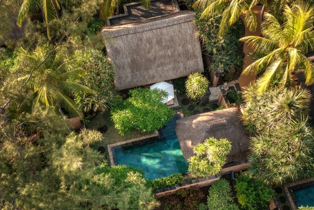 Aerial view of a luxury Mauritius villa featuring a private turquoise pool, thatched roofs, and lush tropical greenery.