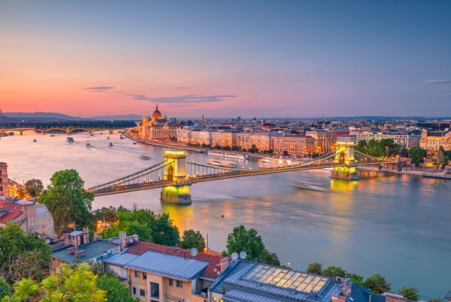 Sunset view of Széchenyi Chain Bridge and Hungarian Parliament Building over the Danube River in Budapest.