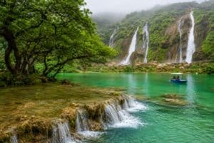 Lush waterfalls and turquoise lagoon in Salalah, Oman during Khareef 2026 travel guide for UAE residents.