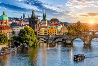 Scenic view of Prague's Charles Bridge and Vltava River at sunset for Czech Republic tour packages from Dubai.