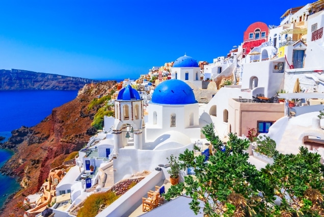 Santorini Oia Greece with whitewashed houses and iconic blue-domed churches above the Aegean Sea