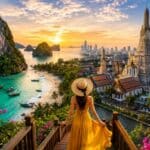 Woman in yellow dress overlooking Railay Beach cliffs and Bangkok's Wat Arun temple at sunset, Thailand 2026