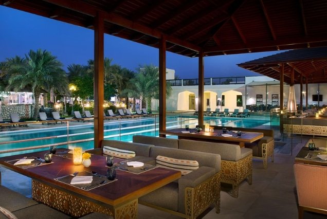 Poolside restaurant with lounge seating at night at Radisson Blu Hotel & Resort, Al Ain