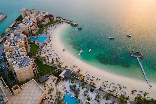 Aerial view of the sandy beach and turquoise water at Rove Al Marjan Island