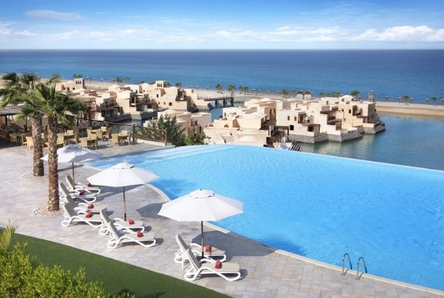 Infinity pool overlooking lagoon villas and the sea at The Cove Rotana Resort Ras Al Khaimah